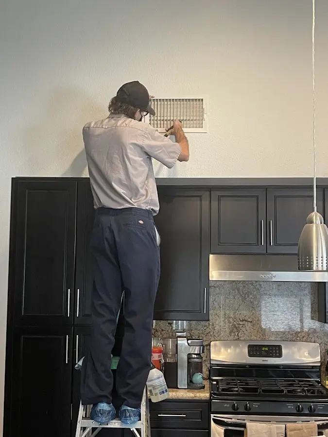 Technician inspecting an air vent during HVAC service in Twin Falls